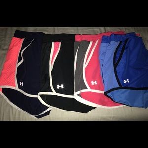 FOUR pairs of UA heat gear running shorts.